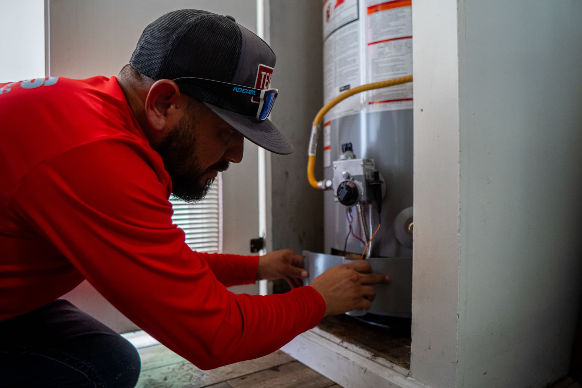 Technician from Texas Plumbing Septic Heating & Air servicing a water heater in Midland